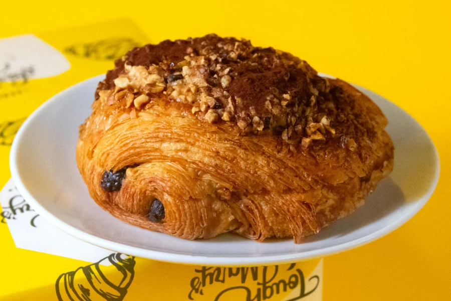 A hazelnut pain au chocolat on a white plate against a yellow background at Tough Mary’s in Nottingham